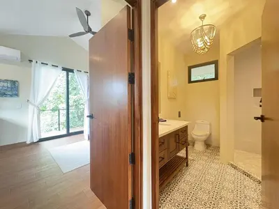 a bathroom with a toilet and a sink and a mirror at Casa Mariposa - villa with infinity pool, near beach in Brasilito