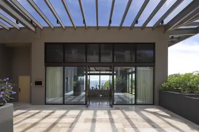a house with glass doors and a roof at Waldorf Astoria Costa Rica Punta Cacique in Playa Hermosa