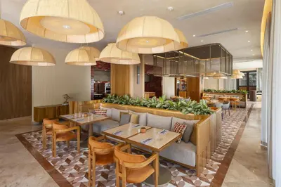 a restaurant with tables and chairs and chandeliers at Waldorf Astoria Costa Rica Punta Cacique in Playa Hermosa