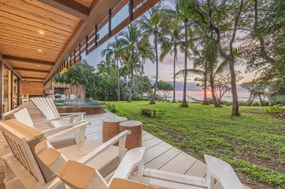 a patio with white chairs and a view of the ocean at Dream On Costa Rica in Santa Cruz