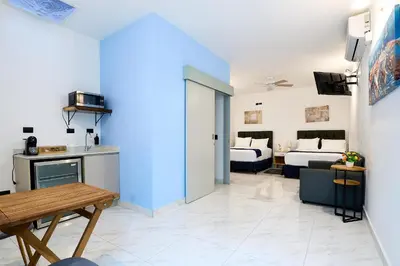 a living room with a blue wall and a living room at Apartaestudios la capital in San José