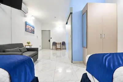 a room with two beds and a couch and a table at Apartaestudios la capital in San José