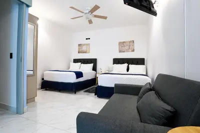 a living room with two beds and a couch at Apartaestudios la capital in San José