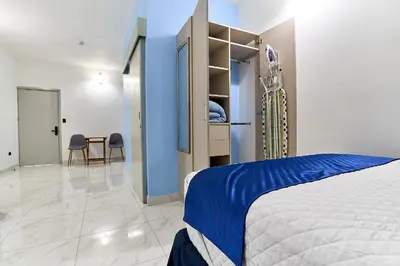 a bedroom with a bed and a blue wall at Apartaestudios la capital in San José