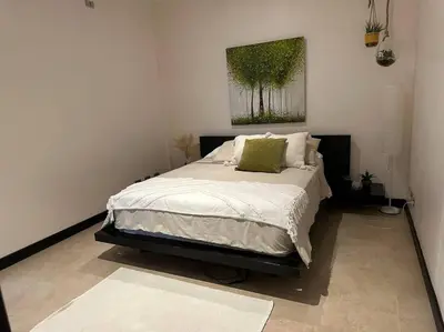 a bedroom with a bed with a painting on the wall at Breathtaking Ocean View Condo in Sámara
