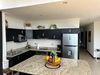 a kitchen with a bowl of fruit on a counter at Breathtaking Ocean View Condo in Sámara