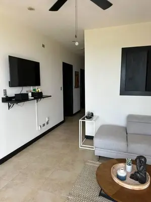 a living room with a couch and a flat screen tv at Breathtaking Ocean View Condo in Sámara