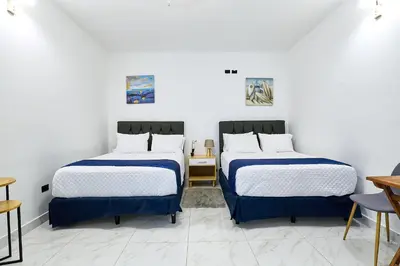 two beds in a room with white walls at Apartaestudio la capital in San José