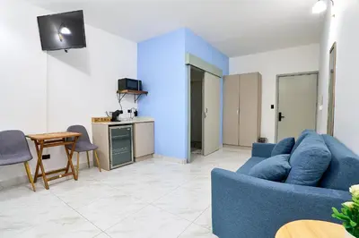 a living room with a blue couch and a table at Apartaestudio la capital in San José