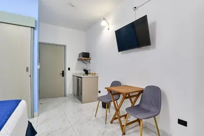 a room with a table and two chairs and a television at #5 Apartaestudio la capital in San José