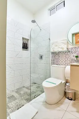 a bathroom with a toilet and a glass shower at #5 Apartaestudio la capital in San José