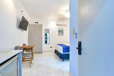 a room with a bed and a table and a kitchen at #5 Apartaestudio la capital in San José