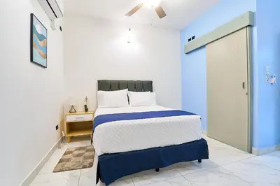 a blue and white bedroom with a bed and a door at #5 Apartaestudio la capital in San José
