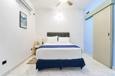 a bedroom with a bed in a white room at #5 Apartaestudio la capital in San José
