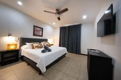 a bedroom with a bed and a ceiling fan at The Palms Ocean Club Resort in Jacó