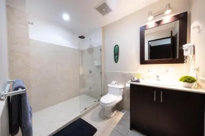 a bathroom with a shower and a toilet and a sink at The Palms Ocean Club Resort in Jacó
