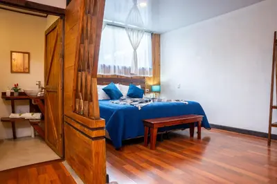 a bedroom with a blue bed and a window at Tierra Buena Countryside Hotel in Monteverde Costa Rica