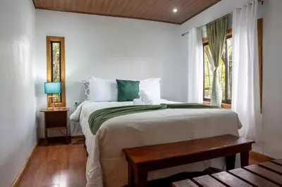a bedroom with a large bed and a window at Tierra Buena Countryside Hotel in Monteverde Costa Rica
