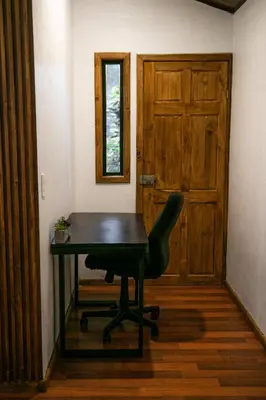 a desk and a chair in a room with a door at Tierra Buena Countryside Hotel in Monteverde Costa Rica