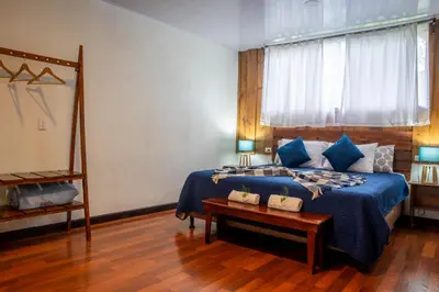 a bedroom with a blue bed and a table at Tierra Buena Countryside Hotel in Monteverde Costa Rica