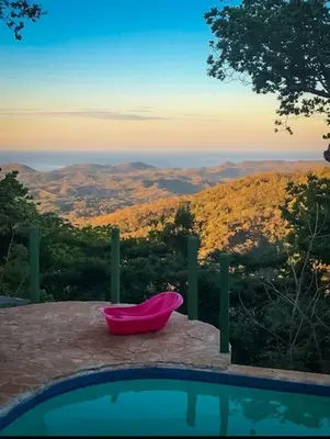 a pink chair sitting next to a swimming pool at Sundancefamily Paradise Villa in Sámara