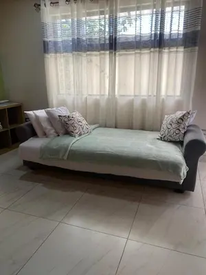a bed sitting in front of a window with curtains at Villas Flakis, Vela in Monteverde Costa Rica