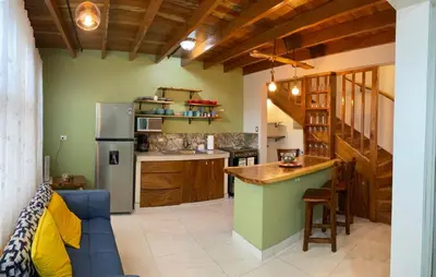 a kitchen with a blue couch and a refrigerator at Villas Flakis, Vela in Monteverde Costa Rica