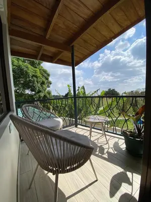 a porch with a chair and a table on a balcony at Villas Flakis, Vela in Monteverde Costa Rica
