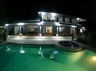 a house with a swimming pool at night at Luxury Villa with Separate Guest house and 360view in Quepos