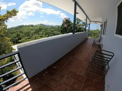 a balcony with chairs and a view of the mountains at Luxury Villa with Separate Guest house and 360view in Quepos