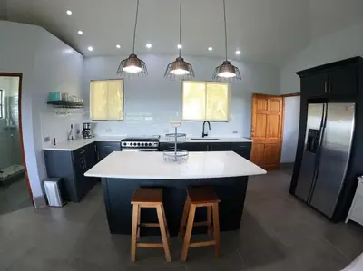 a kitchen with a large white island in the middle at Luxury Villa with Separate Guest house and 360view in Quepos