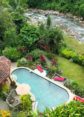 an overhead view of a swimming pool next to a river at Casitas Del Rio Riverfront Nature Lodge in Uvita
