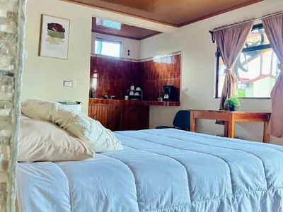 a bedroom with a bed with a blue blanket at Los Tucanes Lodging in El Castillo de La Fortuna