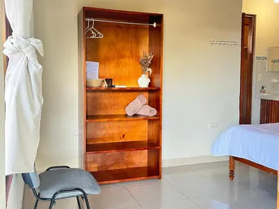 a bedroom with a wooden book shelf next to a bed at Los Tucanes Lodging in El Castillo de La Fortuna