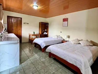 a hotel room with two beds and a kitchen at Los Tucanes Lodging in El Castillo de La Fortuna