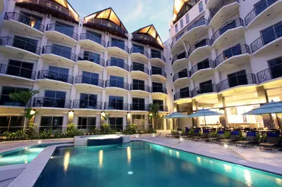 a hotel with a swimming pool in front of a building at Oceano Boutique Hotel & Bistró in Jacó