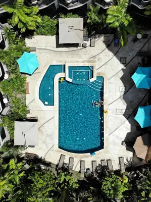 an overhead view of a swimming pool with chairs and trees at Oceano Boutique Hotel & Bistró in Jacó