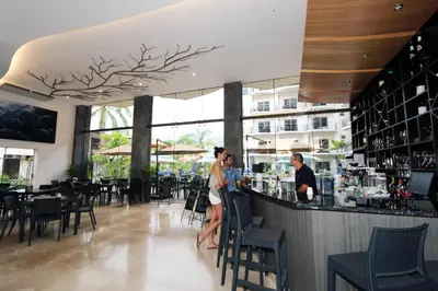 a woman standing at a bar in a restaurant at Oceano Boutique Hotel & Bistró in Jacó