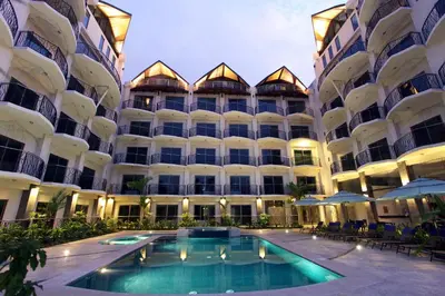 a large building with a swimming pool in front of it at Oceano Boutique Hotel & Bistró in Jacó