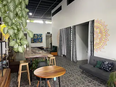a room with a couch and a table and chairs at Asha Hostel in Fortuna