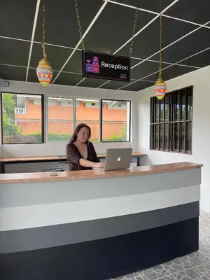 a woman sitting at a counter with a laptop at Asha Hostel in Fortuna