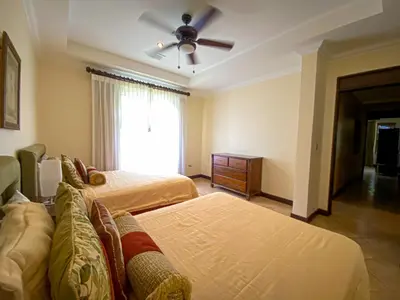 a bedroom with two beds and a ceiling fan at Espacioso Condominio en Pacific Sun in Jacó
