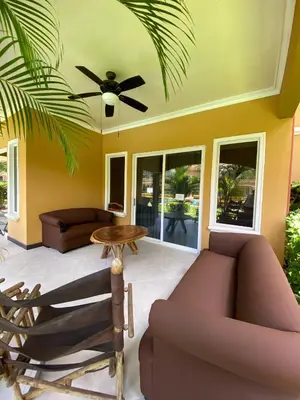 a living room with a ceiling fan and a couch at Espacioso Condominio en Pacific Sun in Jacó