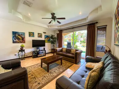 a living room with a couch and a tv at Espacioso Condominio en Pacific Sun in Jacó