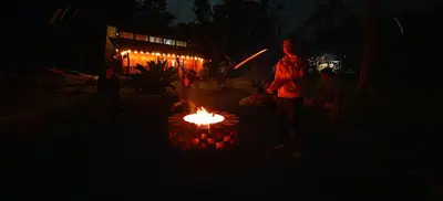 a person standing in front of a fire pit at night at Casa Arthémis - Rainforest Lodge in Guápiles