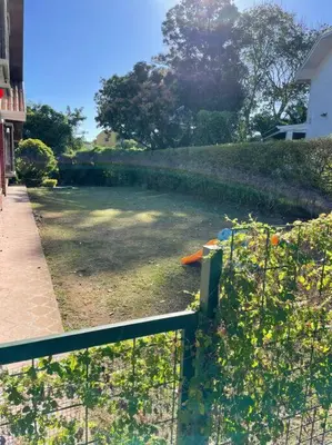 a fence in front of a yard with a hedge at Rainforest Cabin in Escazu in Escazu
