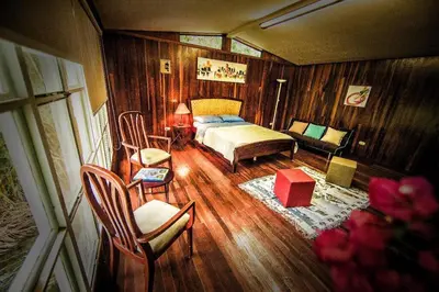 a bedroom with a bed and a couch and a chair at Rainforest Cabin in Escazu in Escazu