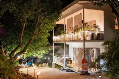 a building with a balcony with a surfboard in front of it at Kai Villa in Santa Teresa Beach