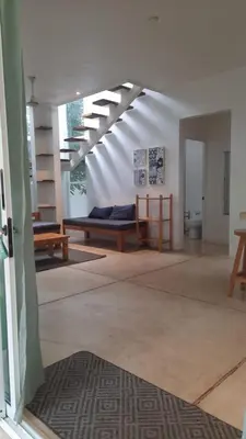 a living room with two benches and a staircase at Kai Villa in Santa Teresa Beach