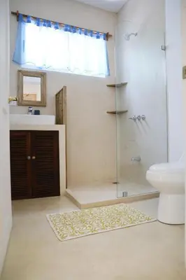 a bathroom with a shower and a sink and a toilet at Kai Villa in Santa Teresa Beach